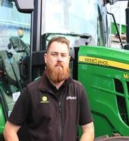 Photo of Stephen Foster from Hutcheon and Pearce in front of a John Deere Tractor